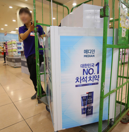 27일 오전 서울의 한 마트 직원이 가습기 살균제에 사용된 화학물질 메칠클로로이소치아졸리논과 메칠이소치아졸리논 혼합물(CMIT/MIT)이 검출된 치약 브랜드의 홍보대를 매장에서 철수시키고 있다. 식품의약품안전처는 이 브랜드의 치약 11종을 회수한다고 26일 발표했다.